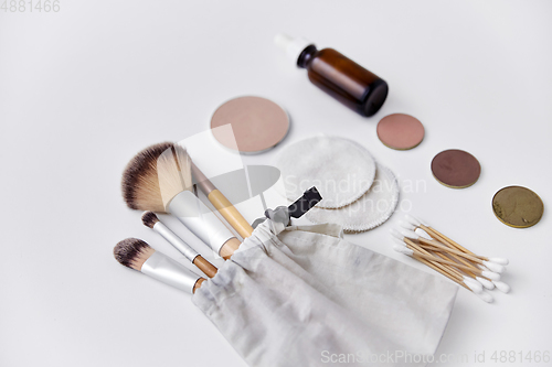 Image of make up brushes, cosmetics and cotton swabs