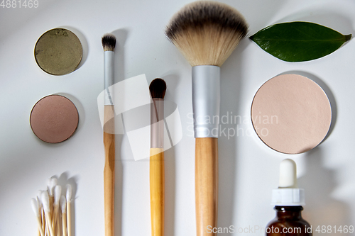 Image of make up brushes, cosmetics and cotton swabs