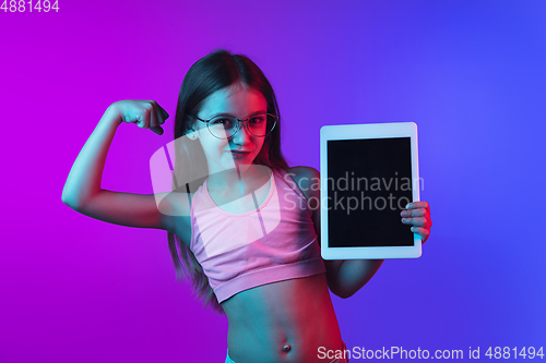 Image of Little caucasian girl\'s portrait isolated on gradient pink-blue background in neon light.