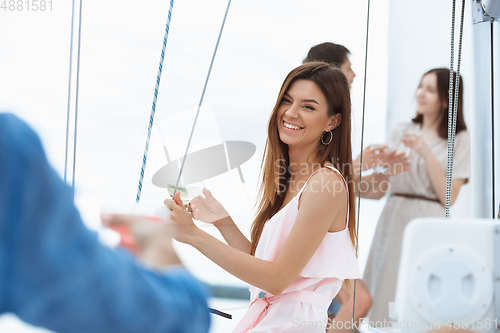 Image of Happy smiling woman drinking vodka cocktails at boat party outdoor, cheerful and happy