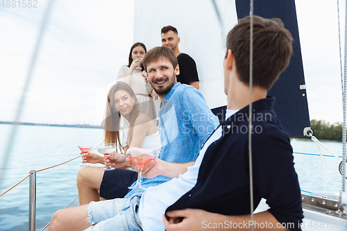 Image of Group of happy friends drinking vodka cocktails at boat party outdoor, cheerful and happy