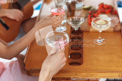 Image of Close up group of happy friends drinking vodka cocktails at boat party outdoor, cheerful and happy