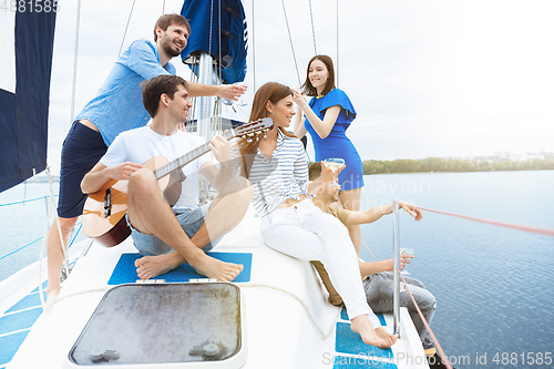 Image of Group of happy friends drinking vodka cocktails at boat party outdoor, cheerful and happy