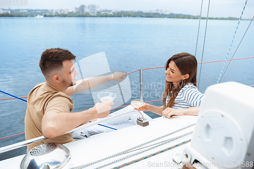 Image of Happy couple drinking vodka cocktails at boat party outdoor, cheerful and happy