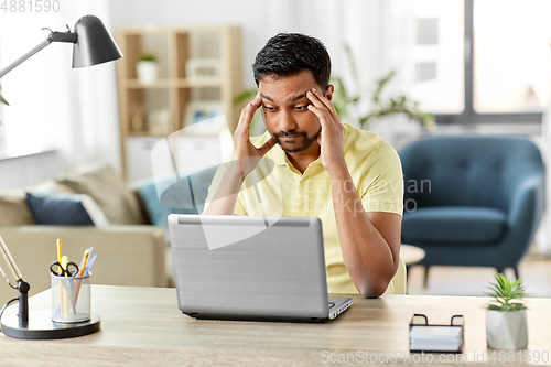 Image of indian man with laptop working at home office