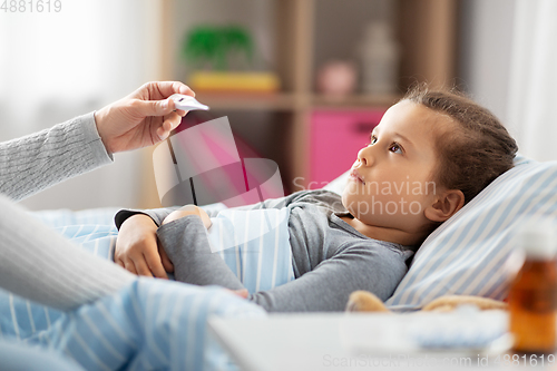 Image of mother measuring temperature of sick daughter