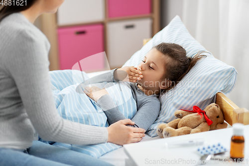 Image of mother and sick little daughter in bed at home