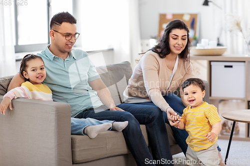 Image of portrait of happy family sitting on sofa at home