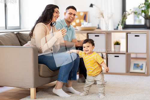 Image of happy family with child sitting on sofa at home