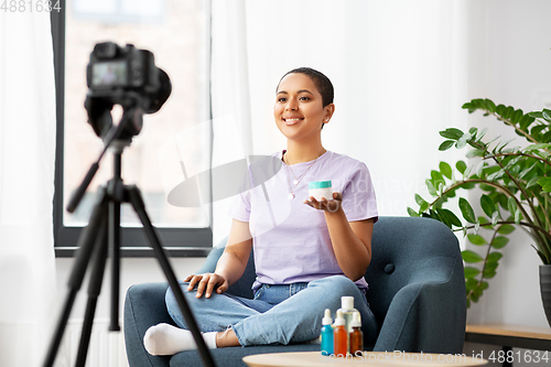 Image of female beauty blogger with camera and cosmetics