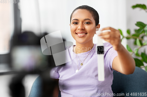 Image of female blogger with camera video blogging at home