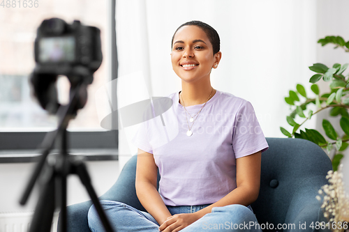 Image of female blogger with camera video blogging at home