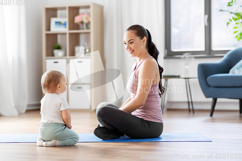 Image of happy mother with little baby at home