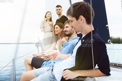 Image of Group of happy friends drinking vodka cocktails at boat party outdoor, cheerful and happy