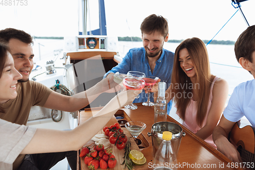 Image of Group of happy friends drinking vodka cocktails at boat party outdoor, cheerful and happy