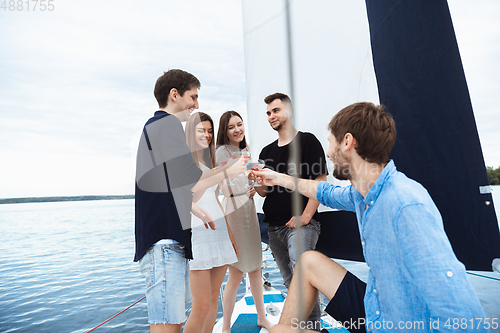 Image of Group of happy friends drinking vodka cocktails at boat party outdoor, cheerful and happy