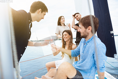 Image of Group of happy friends drinking vodka cocktails at boat party outdoor, cheerful and happy