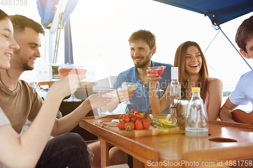 Image of Group of happy friends drinking vodka cocktails at boat party outdoor, cheerful and happy