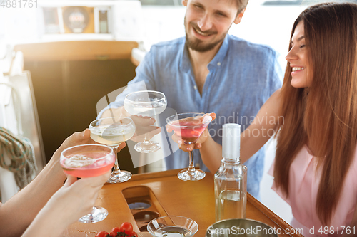 Image of Group of happy friends drinking vodka cocktails at boat party outdoor, cheerful and happy