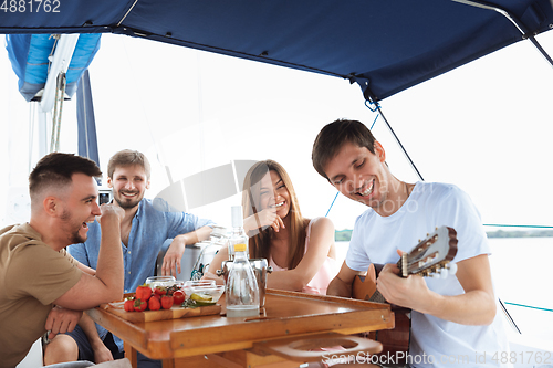 Image of Group of happy friends drinking vodka cocktails at boat party outdoor, cheerful and happy