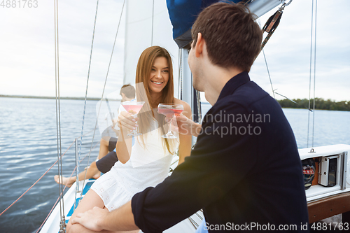 Image of Happy couple drinking vodka cocktails at boat party outdoor, cheerful and happy