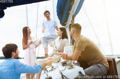 Image of Group of happy friends drinking vodka cocktails at boat party outdoor, cheerful and happy