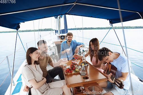 Image of Group of happy friends drinking vodka cocktails at boat party outdoor, cheerful and happy