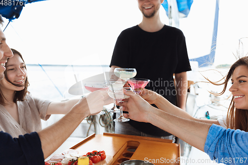 Image of Group of happy friends drinking vodka cocktails at boat party outdoor, cheerful and happy