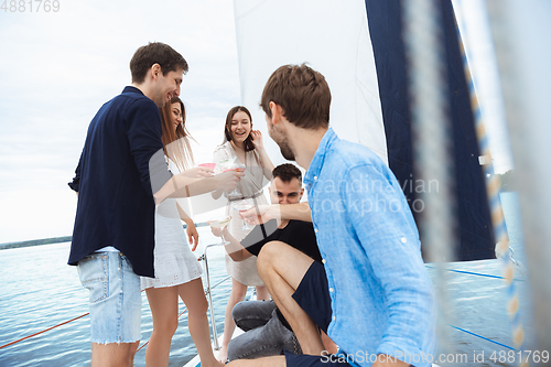 Image of Group of happy friends drinking vodka cocktails at boat party outdoor, cheerful and happy