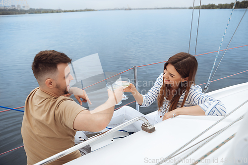 Image of Happy couple drinking vodka cocktails at boat party outdoor, cheerful and happy