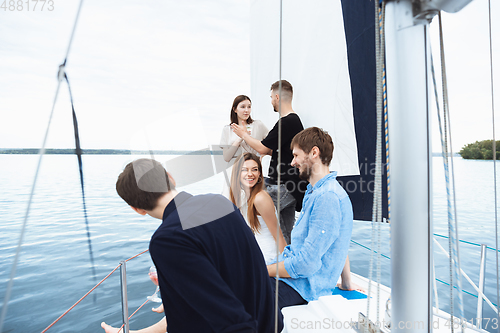 Image of Group of happy friends drinking vodka cocktails at boat party outdoor, cheerful and happy