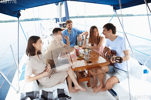 Image of Group of happy friends drinking vodka cocktails at boat party outdoor, cheerful and happy