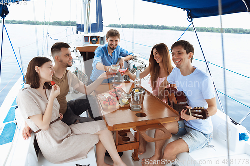 Image of Group of happy friends drinking vodka cocktails at boat party outdoor, cheerful and happy