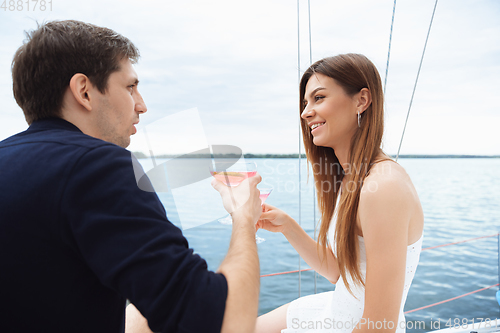 Image of Happy couple drinking vodka cocktails at boat party outdoor, cheerful and happy