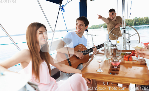 Image of Group of happy friends drinking vodka cocktails at boat party outdoor, cheerful and happy