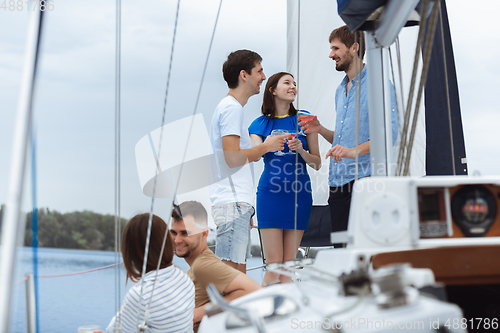 Image of Group of happy friends drinking vodka cocktails at boat party outdoor, cheerful and happy