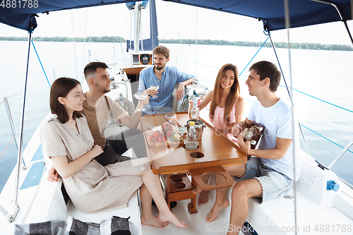 Image of Group of happy friends drinking vodka cocktails at boat party outdoor, cheerful and happy