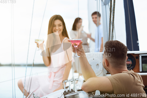 Image of Happy couple drinking vodka cocktails at boat party outdoor, cheerful and happy