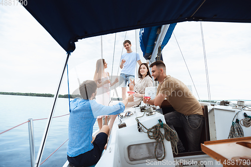 Image of Group of happy friends drinking vodka cocktails at boat party outdoor, cheerful and happy