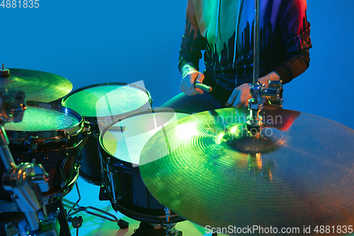 Image of Young caucasian musician playing on gradient background in neon light. Concept of music, hobby, festival