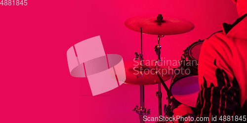 Image of Young caucasian musician playing on gradient background in neon light. Concept of music, hobby, festival