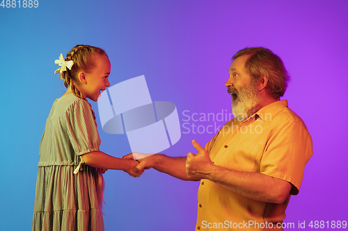 Image of Senior man, grandfather having fun and spending time together with girl, granddaughter. Joyful elderly lifestyle concept