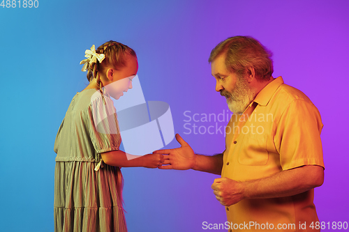 Image of Senior man, grandfather having fun and spending time together with girl, granddaughter. Joyful elderly lifestyle concept
