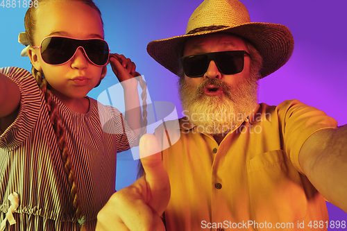 Image of Senior man, grandfather having fun and spending time together with girl, granddaughter. Joyful elderly lifestyle concept