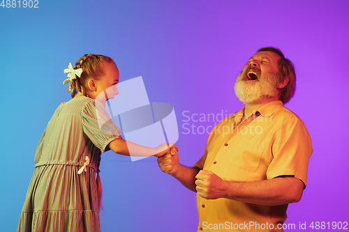 Image of Senior man, grandfather having fun and spending time together with girl, granddaughter. Joyful elderly lifestyle concept