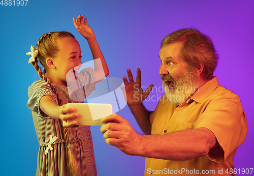 Image of Senior man, grandfather having fun and spending time together with girl, granddaughter. Joyful elderly lifestyle concept