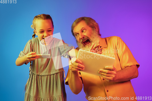 Image of Senior man, grandfather having fun and spending time together with girl, granddaughter. Joyful elderly lifestyle concept