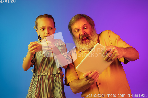 Image of Senior man, grandfather having fun and spending time together with girl, granddaughter. Joyful elderly lifestyle concept