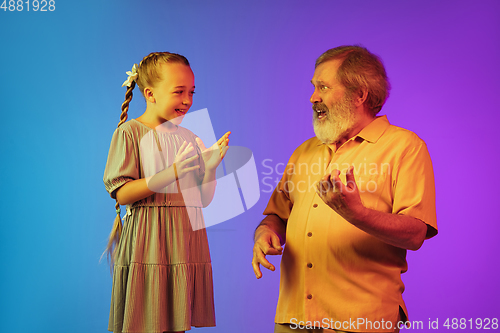Image of Senior man, grandfather having fun and spending time together with girl, granddaughter. Joyful elderly lifestyle concept