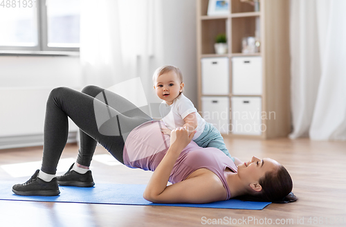 Image of happy mother with little baby exercising at home